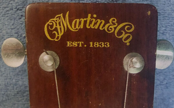 La cabeza de una Guitarra Martin con el logo dorado.