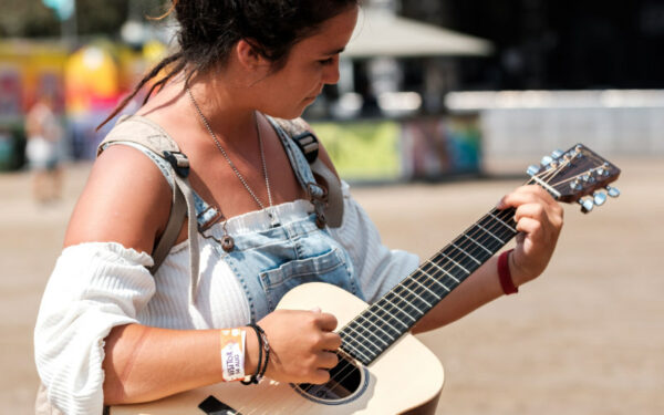 Una mujer tocando la guitarra acústica Little Martin LX1.