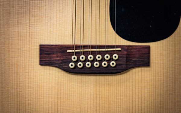 El puente de una guitarra acústica Martin D-X2E de 12 Cuerdas.