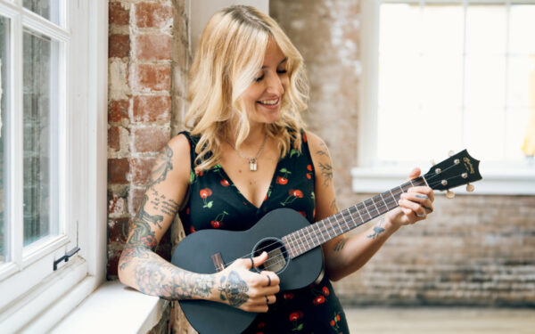 Mujer tocando el ukulele Martin 0X Black